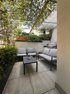 a patio with couches and a table and plants at SilverHome in Lecco
