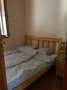 a bedroom with a bed with two pillows on it at Kroni vendégház in Tiszanána
