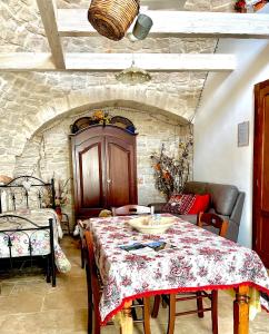 Un comedor con una mesa y una pared de piedra. en Trullo di Giovannina Casa Vacanza, en Alberobello