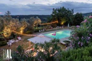 a swimming pool in a garden at night at Cottage nel Chianti con piscina in Castellina in Chianti