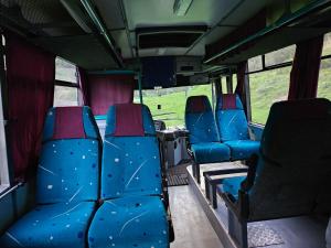 an empty bus with blue seats on a bus at Bed in Bus in Kolárovice