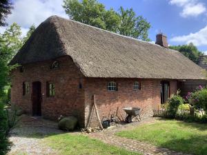 ニービュルにあるFerienwohnung-Austernfischerの草屋根の古いレンガ造りの家