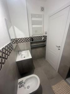 レヴァントにあるAppartamento centralissimoの洗面台とトイレを備えた白いバスルーム