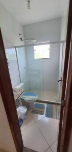ein Badezimmer mit Toilette und Glasdusche in der Unterkunft casa dois quartos completa em saquarema, barra nova in Saquarema