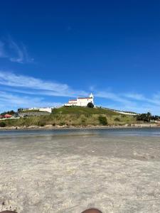 ein Haus auf einem Hügel neben einem Wasserkörper in der Unterkunft casa dois quartos completa em saquarema, barra nova in Saquarema