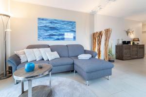 a living room with a blue couch and a table at Blankwasserweg 57 Wohnung 5 in Grömitz