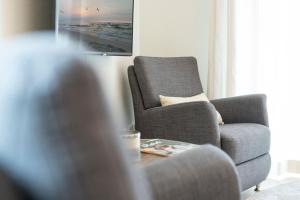 a living room with a chair and a table at Blankwasserweg 57 Wohnung 5 in Grömitz