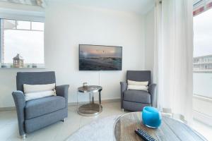 a living room with two chairs and a table at Blankwasserweg 57 Wohnung 5 in Grömitz +30 photos