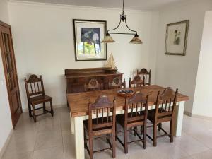 Un comedor con mesa y sillas de madera. en Casa da Laranjeira, en Alvor