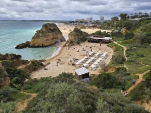 una playa con un grupo de personas en la arena en Casa da Laranjeira, en Alvor