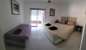 una habitación con dos camas y un sofá en Casa da Laranjeira, en Alvor