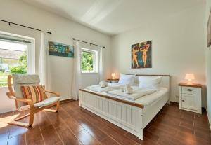 a bedroom with a bed and a chair and a window at Ferienbungalow LEO in Petersdorf auf Fehmarn