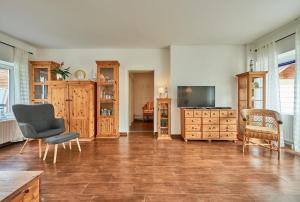 a living room with a television and wooden furniture at Ferienbungalow LEO in Petersdorf auf Fehmarn