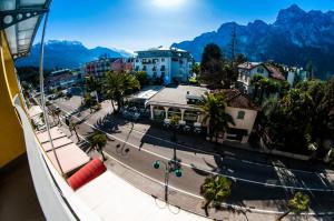 widok na ulicę w mieście z górami w obiekcie Hotel Primo w mieście Riva del Garda