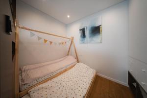 a bedroom with a bunk bed and a painting at Debesu kopa in Nida
