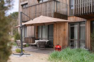a patio with an umbrella next to a building at Debesu kopa in Nida