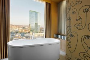 una bañera en un baño con ventana en Renaissance Zurich Tower Hotel, en Zúrich