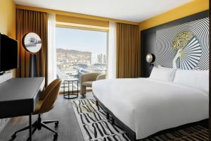 Una habitación de hotel con una cama, un escritorio y una ventana. en Renaissance Zurich Tower Hotel, en Zúrich