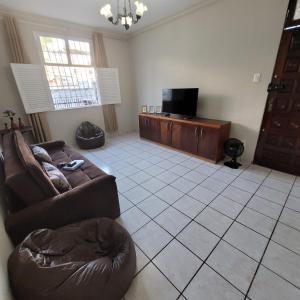 a living room with a couch and a flat screen tv at casa em rua tranquila a 200 metros do agito do Rio Vermelho e praia in Salvador