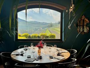 a table in a restaurant with a large window at Panoramic Villa Garassino - country rooms and fine restaurant in Treiso