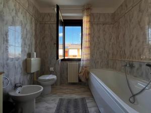 a bathroom with a tub and a toilet and a sink at Villa Grifone in Sirmione +16 photos