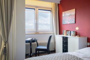 a bedroom with a bed and a chair and a window at Berolina Balkonfeuer in Dahme