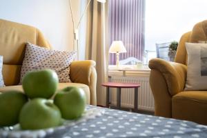 a room with two chairs and a table with green apples at Berolina Balkonfeuer in Dahme