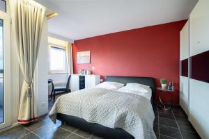 a bedroom with a red wall and a bed at Berolina Balkonfeuer in Dahme