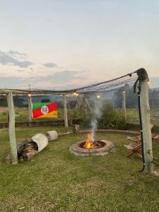 a fire pit in a yard with a flag at Cabanas Colina Do Sol in Cambara do Sul +36 photos