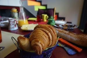 ein Laib Brot in einer blauen Schüssel auf einem Tisch in der Unterkunft La Maison Rouge in Paris