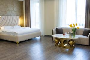 una camera da letto con un letto, un divano e un tavolo di Fidji Hotel a Yerevan