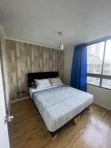 a bedroom with a bed and a blue curtain at Apart Hotel "La Casa de Hersilia" in Santiago