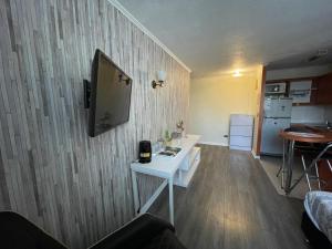 a living room with a white table and a tv on a wall at Apart Hotel "La Casa de Hersilia" in Santiago