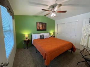 a bedroom with an orange bed and a ceiling fan at Lovers Landing - private hot tub and pet friendly in Ruidoso