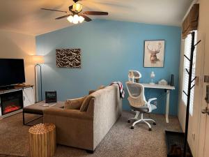 a living room with a couch and a chair and a desk at Lovers Landing - private hot tub and pet friendly in Ruidoso