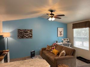 a living room with a couch and a ceiling fan at Lovers Landing - private hot tub and pet friendly in Ruidoso
