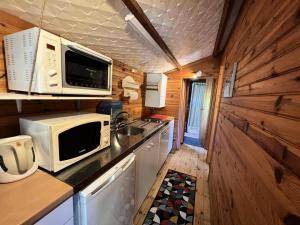 a small kitchen with a microwave and a sink at Résidence 083-le Verdon Sur Mer - 083 - Vue imprenable sur Port Médoc MAE-4421 in Le Verdon-sur-Mer +11 photos