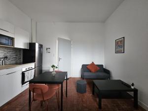 a small living room with a table and a couch at West Side Story - Wifi ,City center in Beaupréau +25 photos