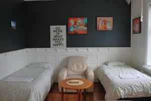a bedroom with two beds and a table and a chair at Ice apartment 2 in Reykjavík