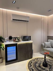 a living room with a tv and a couch at استديو فاخر بجلسه ودخول ذاتي in Al Hofuf