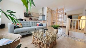 a living room with a couch and a glass table at LÉchappée ZAisne jacuzzi et sauna in Saint-Quentin