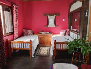 twee bedden in een kamer met rode muren bij Casa rural Eguzkilore in Etuláin