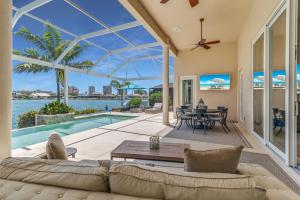 a living room with a couch and a table at Southern Exposure I Waterfront 5 Bed House I Wide Water Views of Landmark Bay in Marco Island