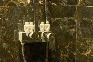 un bagno con un rubinetto con quattro bottiglie di Fidji Hotel a Yerevan