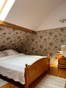 a bedroom with a bed in a room with wallpaper at Dworek Szyszki - Kaszuby in Liniewko