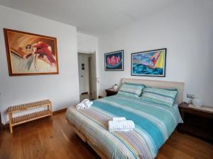a bedroom with a bed and paintings on the wall at Casa Nora in Dervio