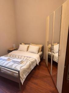 a small bedroom with a bed and a mirror at Enios Rooms Hostel Zwierzyniecka 6 in Kraków