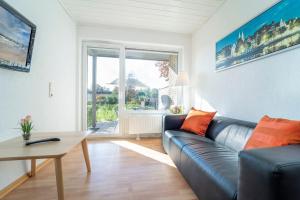 a living room with a leather couch and a table at Blankwasserweg 131 Lensterstrand Oase Bungalow 2 in Lenste +30 photos