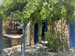 a table and chairs under a grape tree at Kanala Sea-Side Cycladic Cottage I in Kanala +54 photos