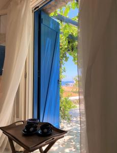 a table with two cups on it next to a blue door at Cycladic Cottage in Kanala